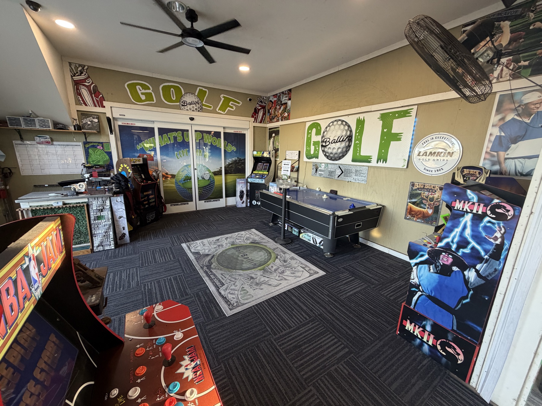 Game room with NBA Jam and Mortal Kombat arcade cabinets, an air hockey table and GolfBallin wall art